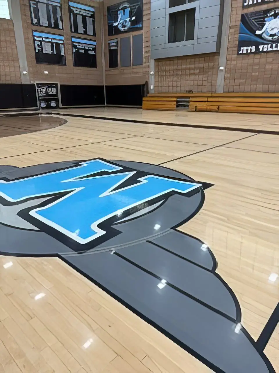 Custom blue center-court logo on a gymnasium floor