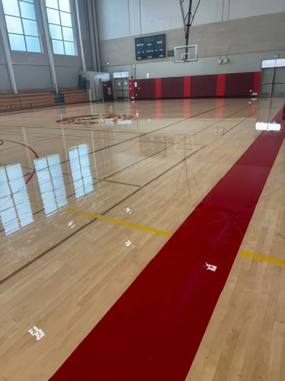 Freshly recoated gymnasium floor with red sideline stripe