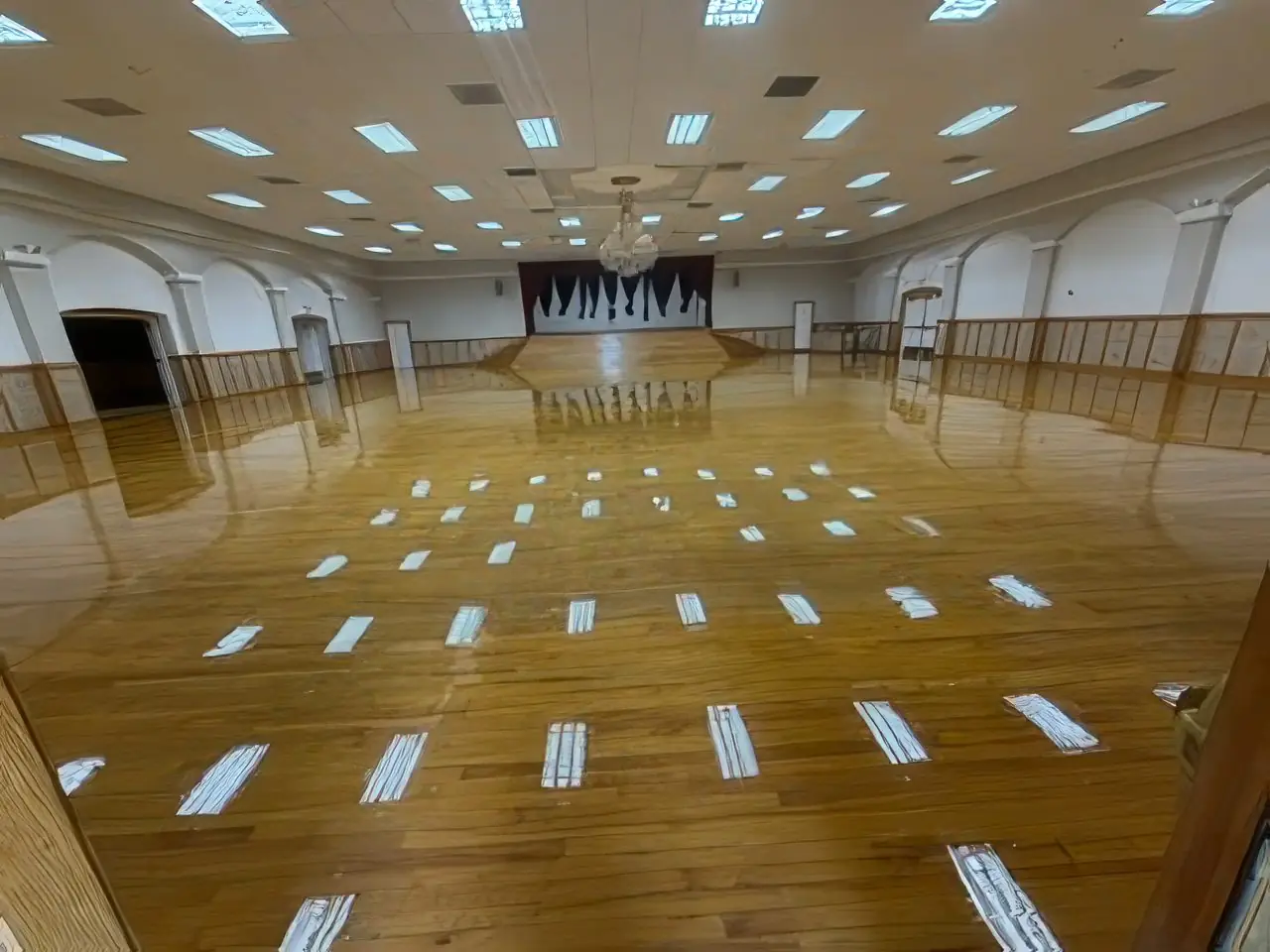 Refinished wood floor in a large multipurpose hall with stage