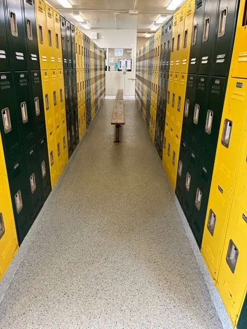 Locker room with new speckled resinous floor between green and yellow lockers