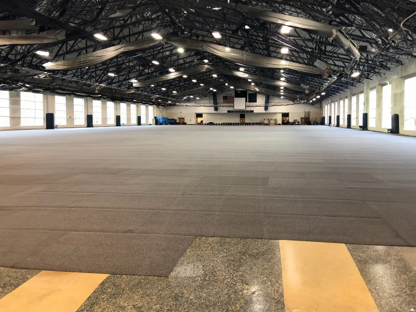 Large field house covered with grey floor-protection tiles