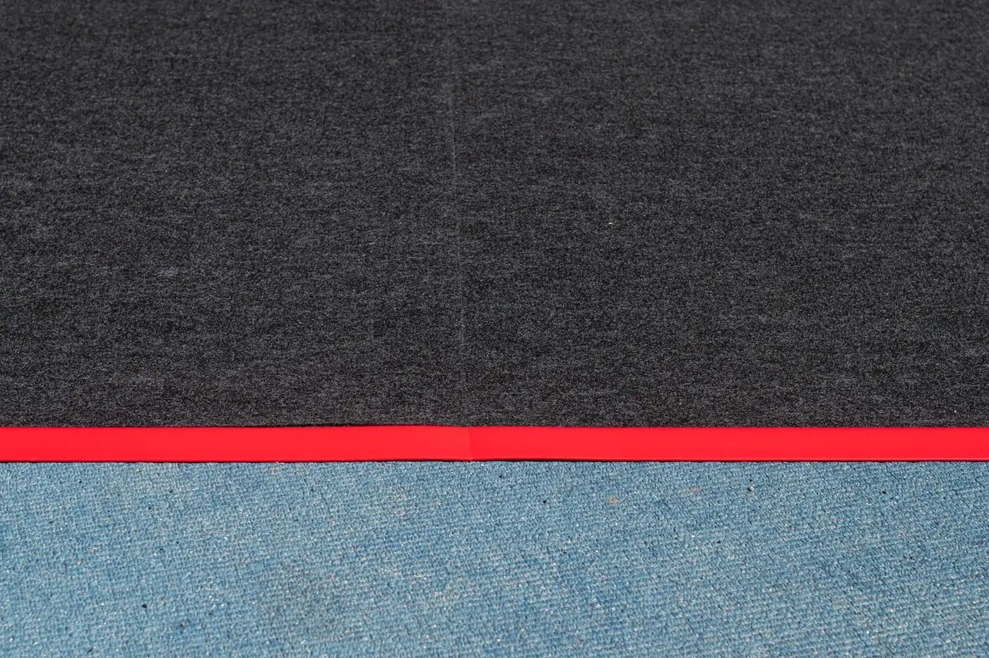 Dark protective runner laid across a red running track