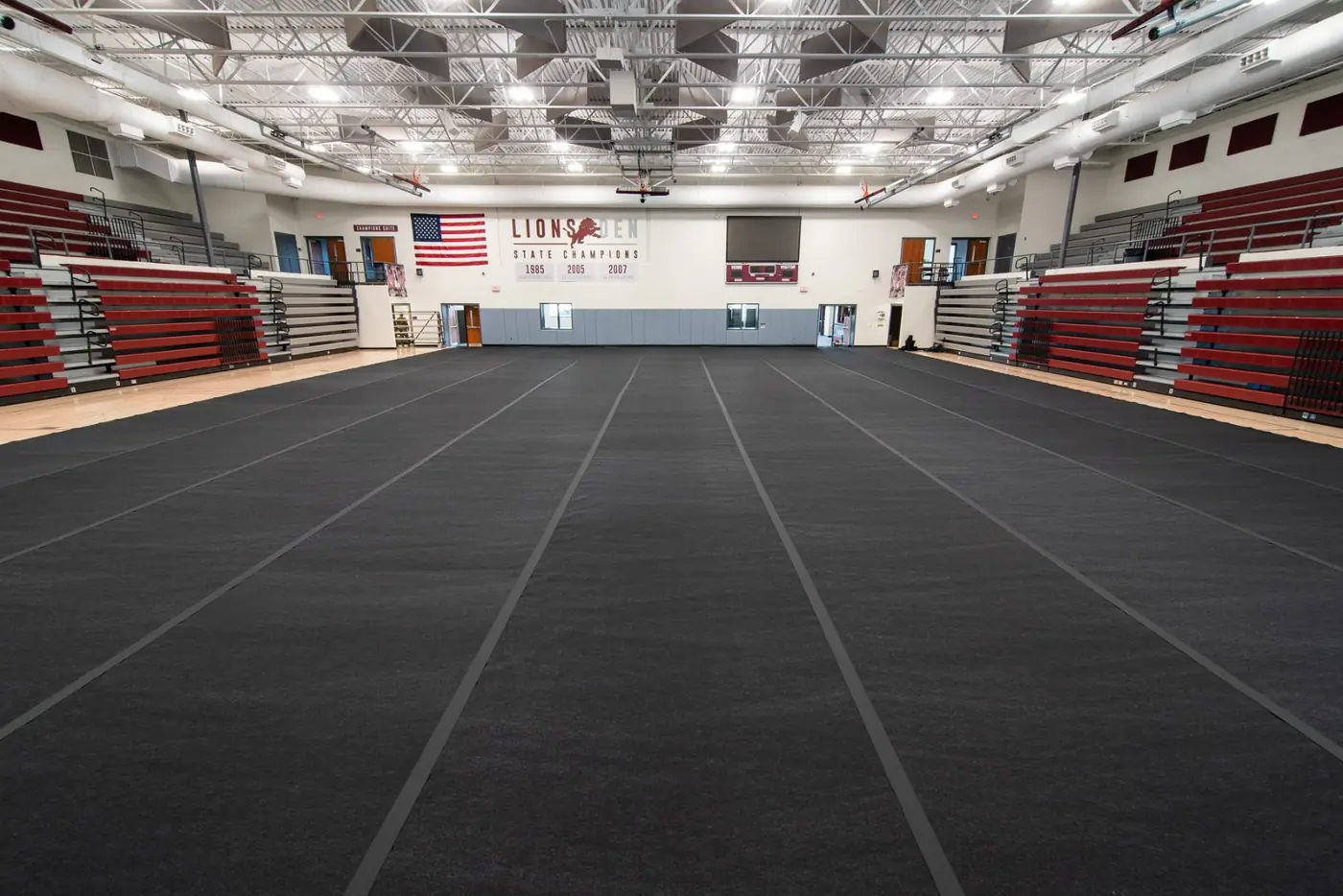 Gymnasium court covered with dark floor-protection rolls for an event